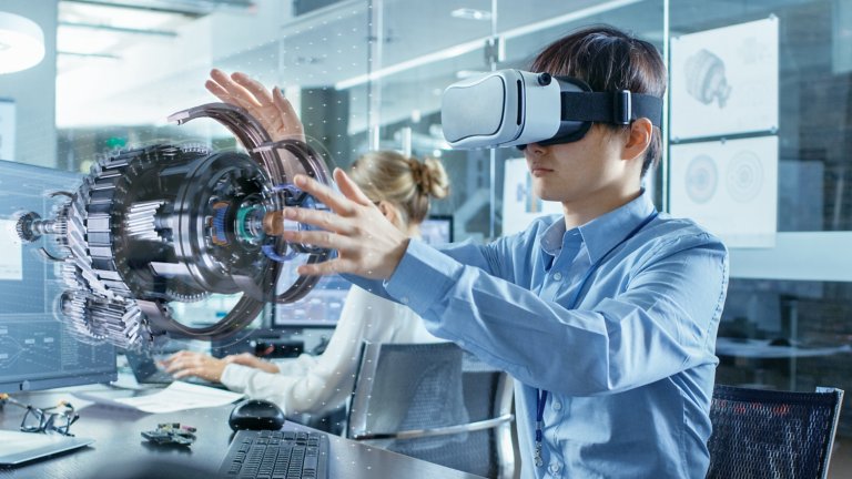 Computertechniker mit einem VR-Headset, der mit der Hologramm-Visualisierung eines 3D-Modells arbeitet.