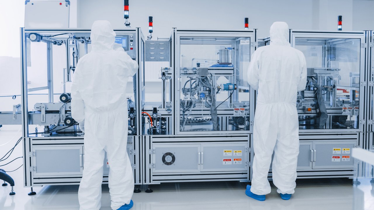 Manufacturing Laboratory where Scientists in Protective Coverall's Work with Industrial High Precision 3D Printing Machinery. Manufacturing Pharmaceutical / Technological / Industrial Products.