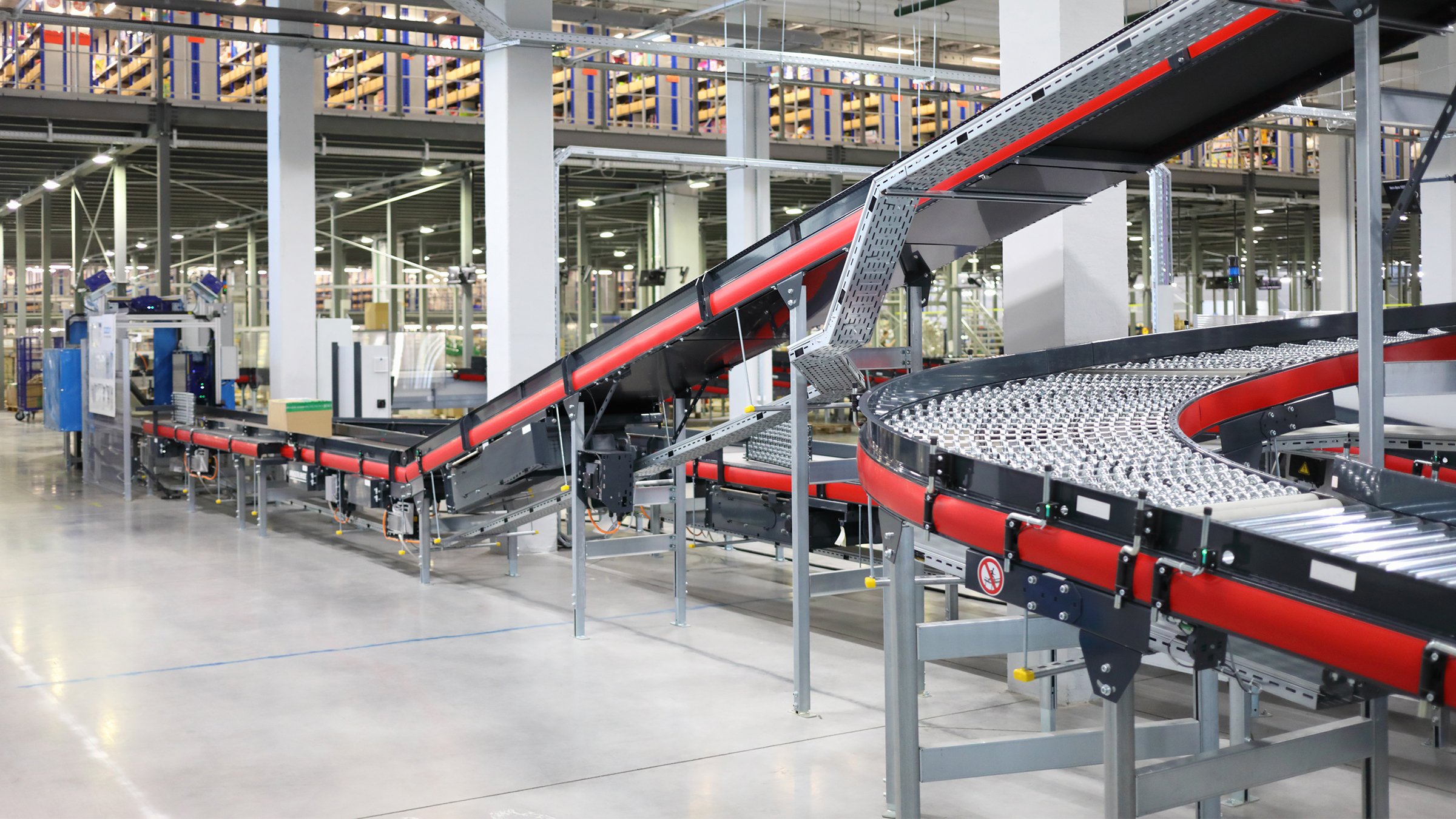 Large warehouse with a metal conveyor transporting goods