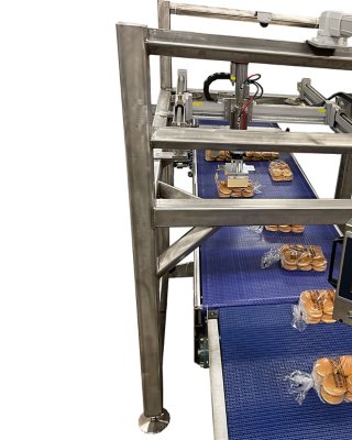 Sandwich buns enter the LeMatic P7 pattern former single file on a blue conveyor. An Allen-Bradley PanelView monitor is affixed above the conveyor.