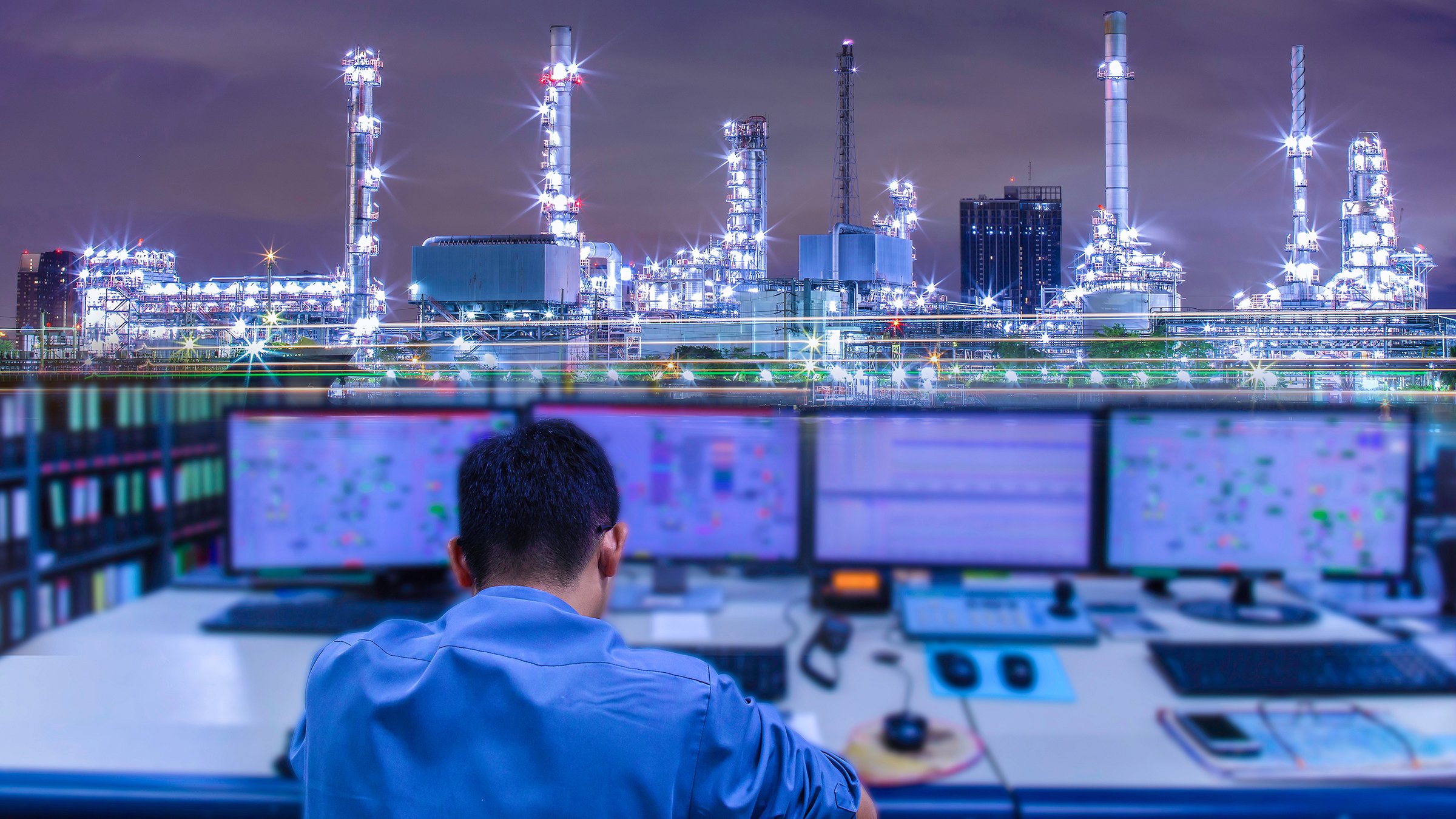 Engineering works with the tablet in the production control room of an oil refinery