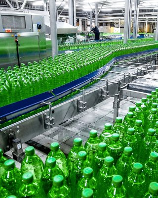 Green plastic bottles on a conveyor in a factory