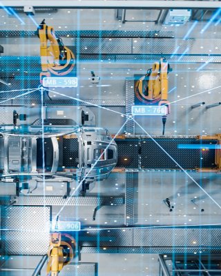 Aerial view of automated assembly line with robots manufacturing high tech electric cars