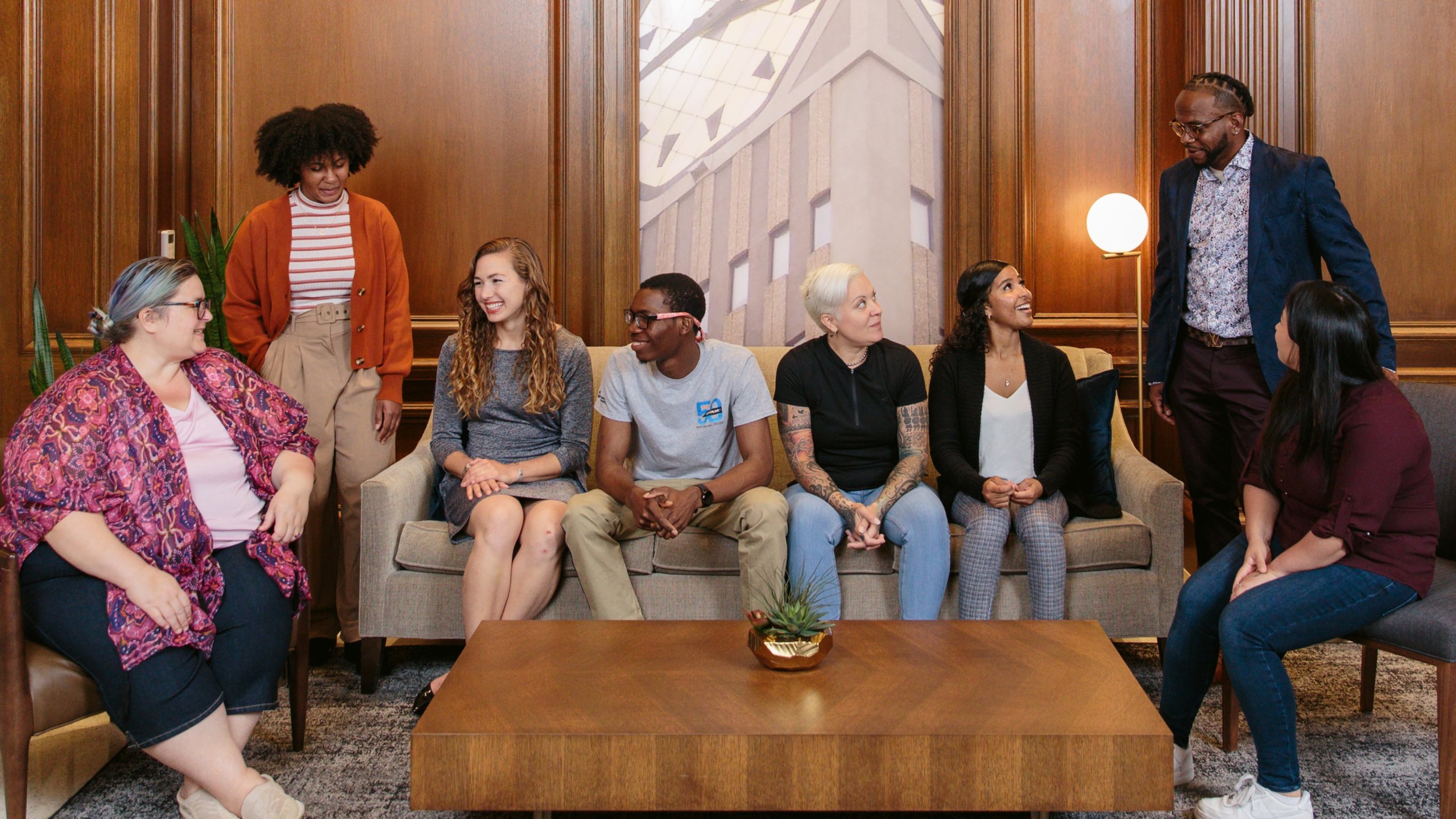 A diverse group of Rockwell employees gathers by a photo of the clocktower in the lobby of the headquarters building in Milwaukee.