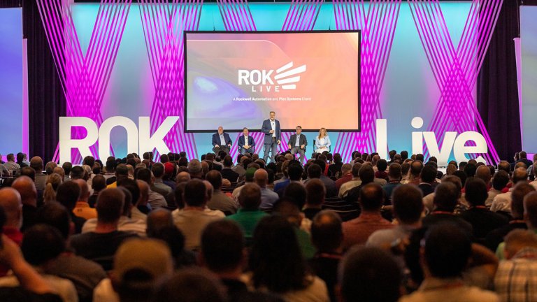 5 people on stage in front of screen presenting to audience at ROKLive 2022 Keynote