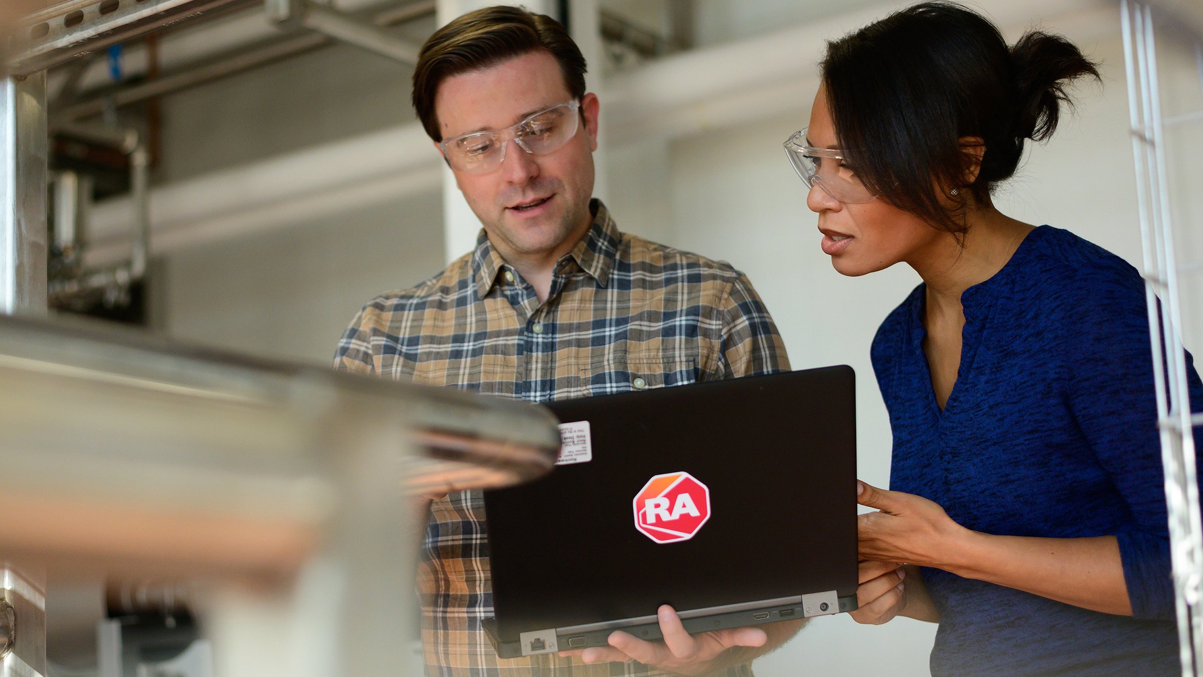 Two RA employees looking at laptop