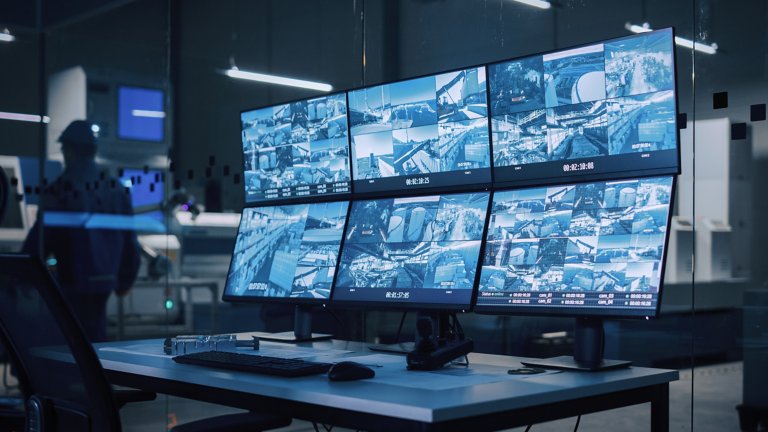  Salle de commande de sécurité avec plusieurs écrans d’ordinateurs montrant des flux d’images de caméras de surveillance. Cybersécurité industrielle