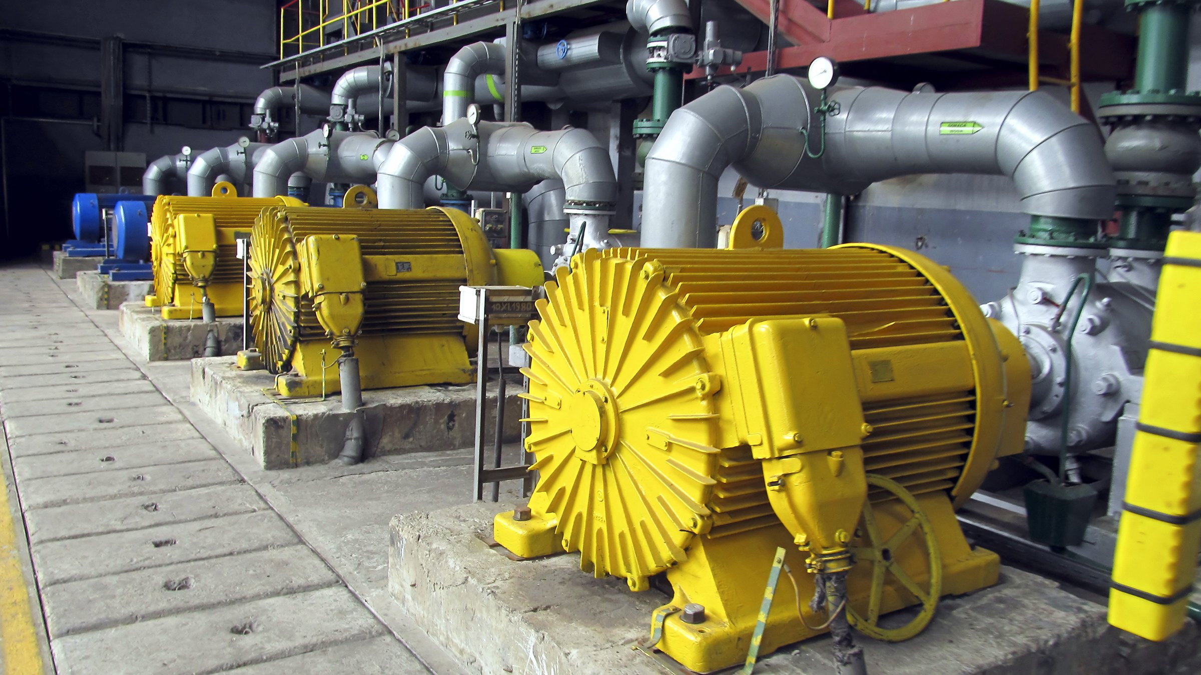 Several yellow industrial water pumps with large electric motors.