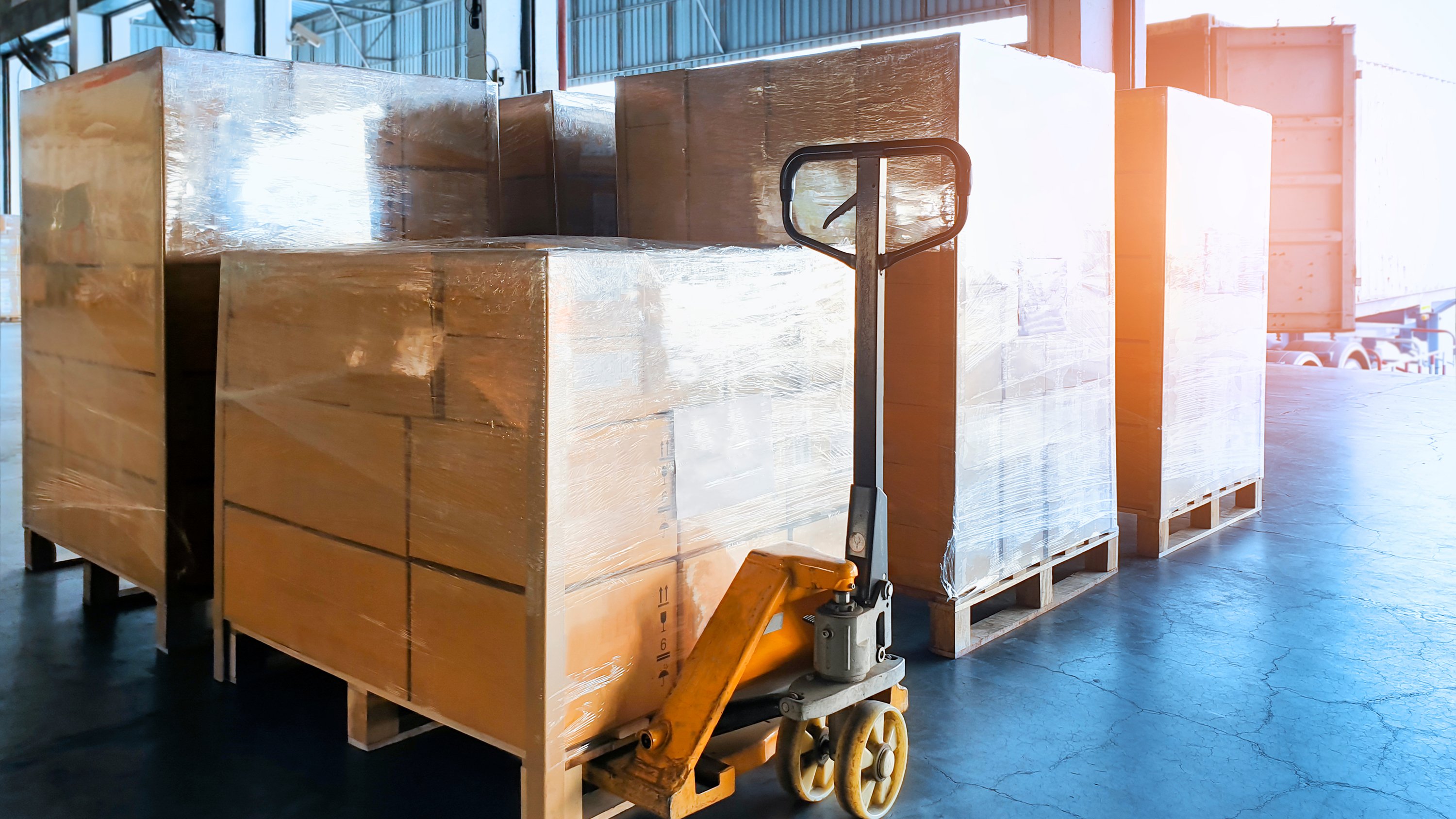 Cardboard boxes stacked and wrapped in plastic for shipping in warehouse