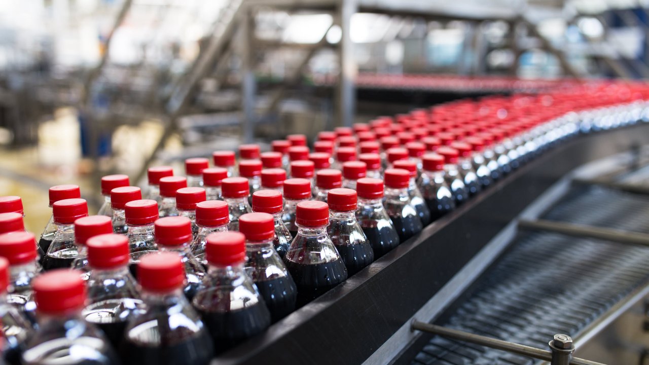 soda bottles move down conveyor belt food and beverage