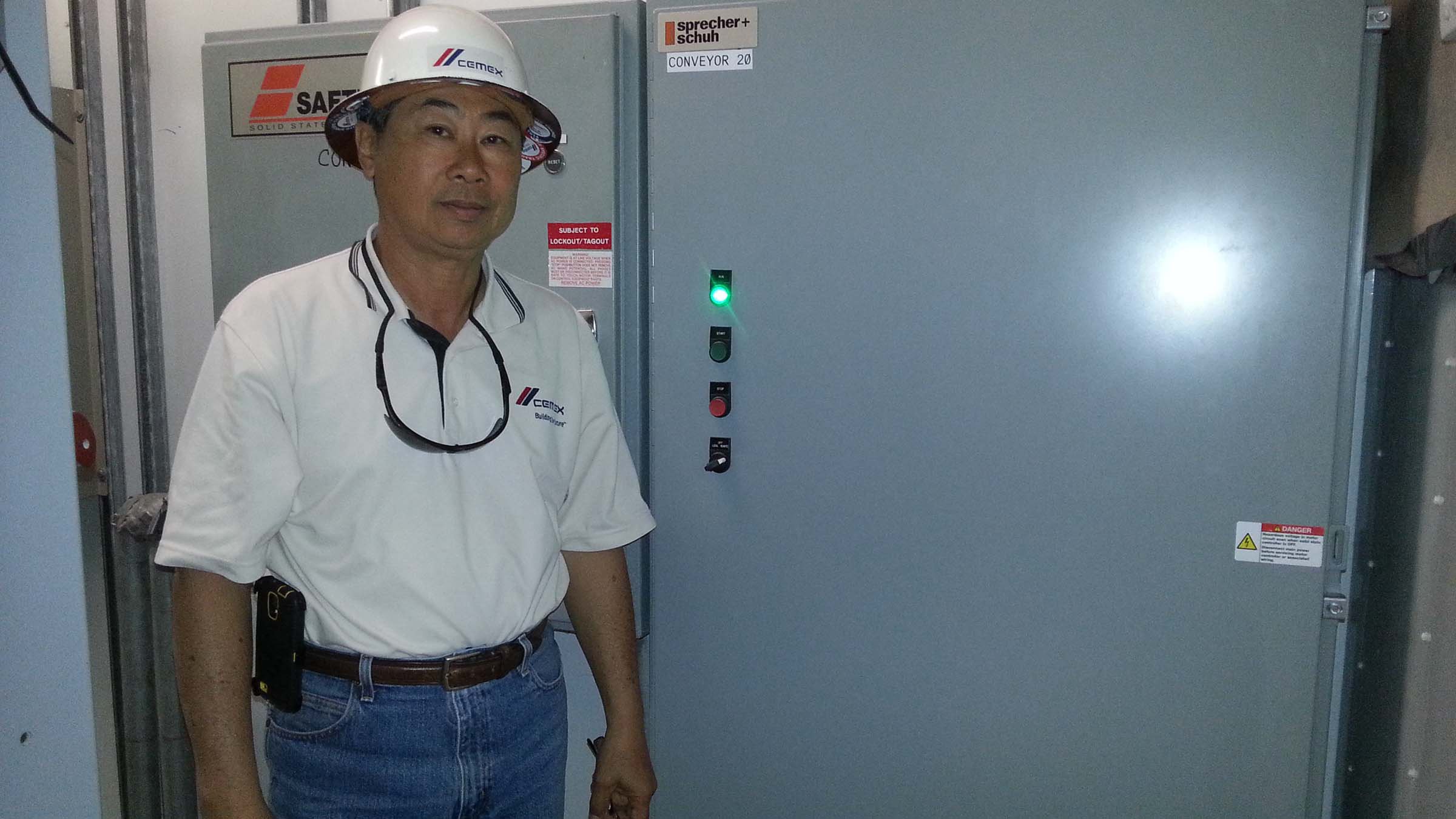 Eddie Yi, Aggregate Division Project Manager at Cemex standing in front of multi-softstarter motor control panel