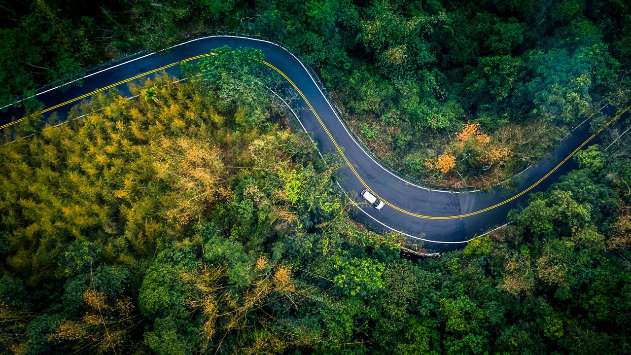 Car driving through a winding road in a forest or scenic landscape
