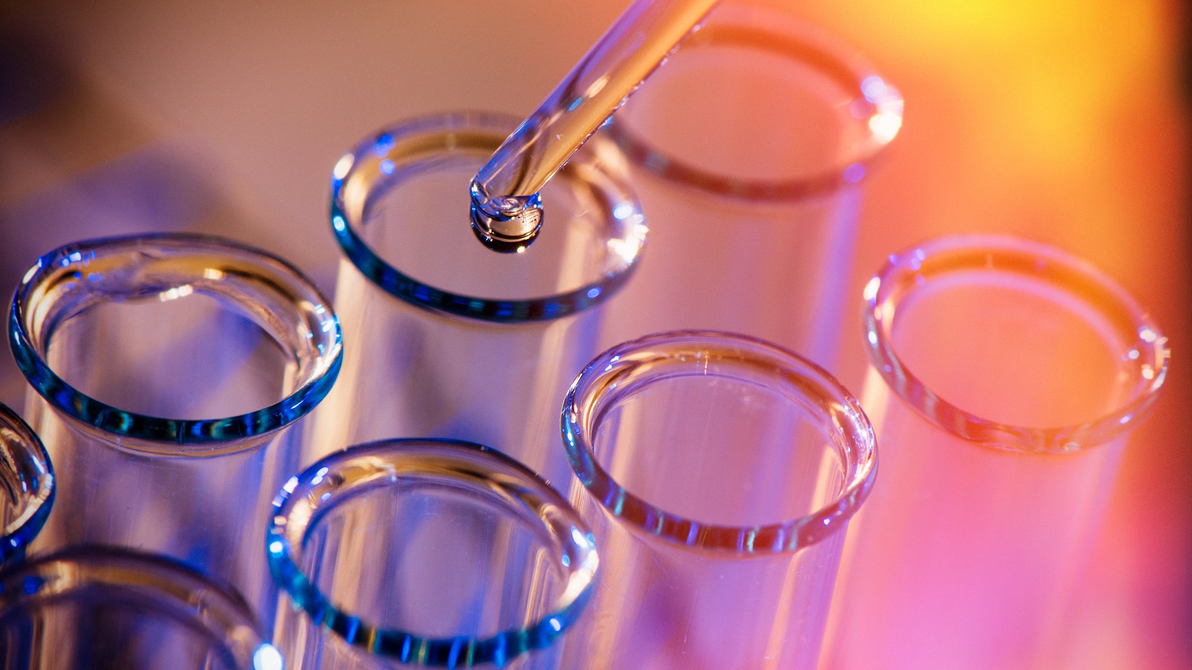 Test tube row. Concept of medical or science laboratory, liquid drop droplet with dropper in blue red tone background, close up, macro photography picture.