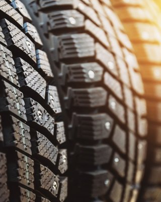 New winter tires for sale in store, selective focus, sunlight effect. Close up view.