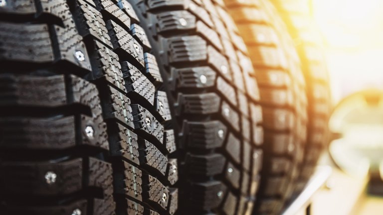 New winter tires for sale in store, selective focus, sunlight effect. Close up view.