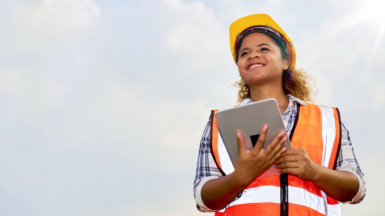 Woman in a hard hat against a cloudy sky