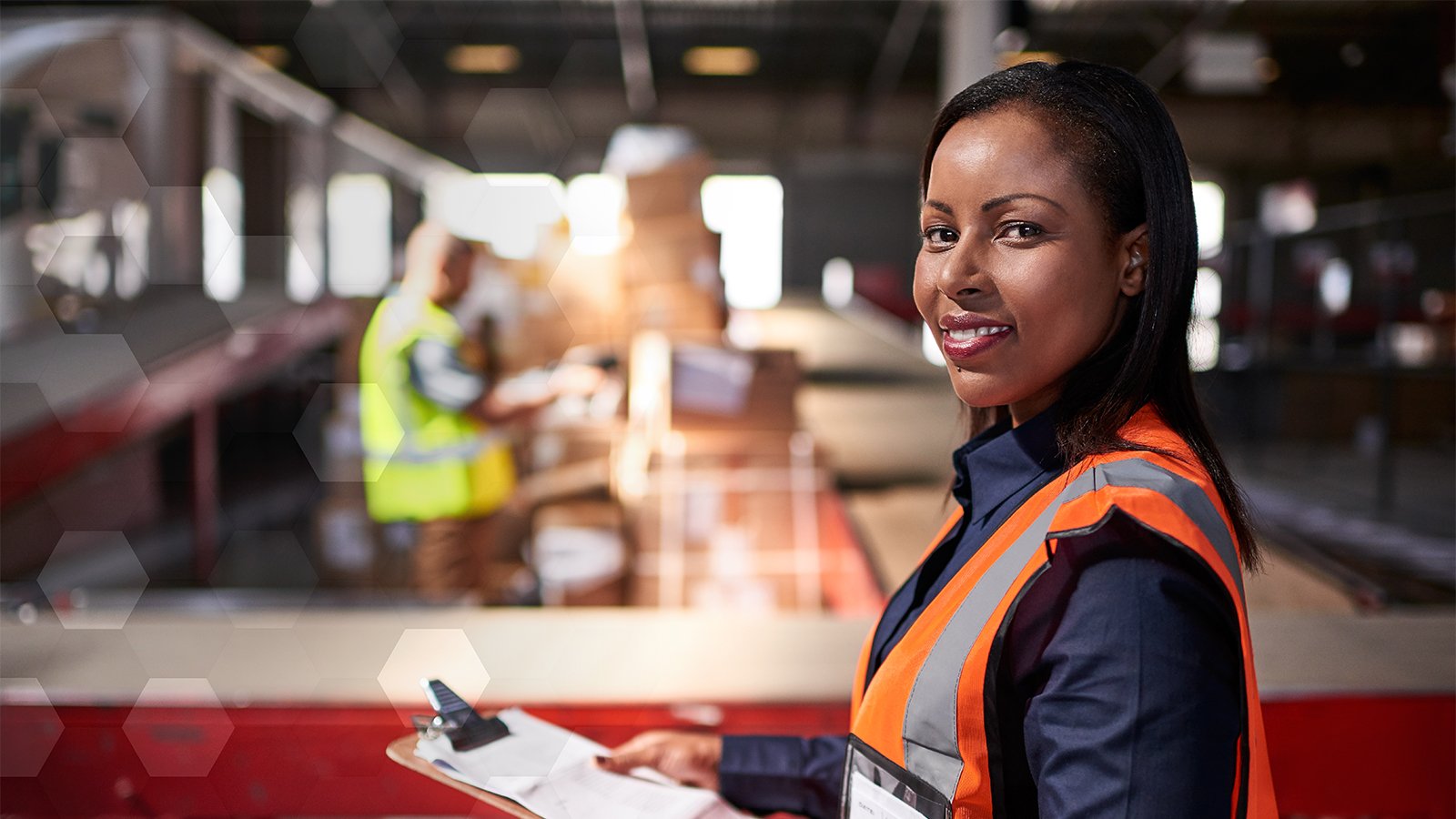 Femme portant un gilet de sécurité dans un atelier préparant un audit annuel des procédures de verrouillage/signalisation