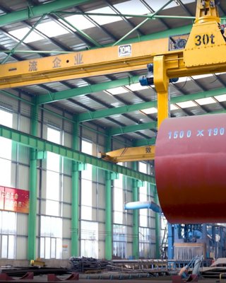 Overhead crane lift up steel coil with tong in wearhouse. Steel coils handling equipment. Steel warehouse and logistics operations.