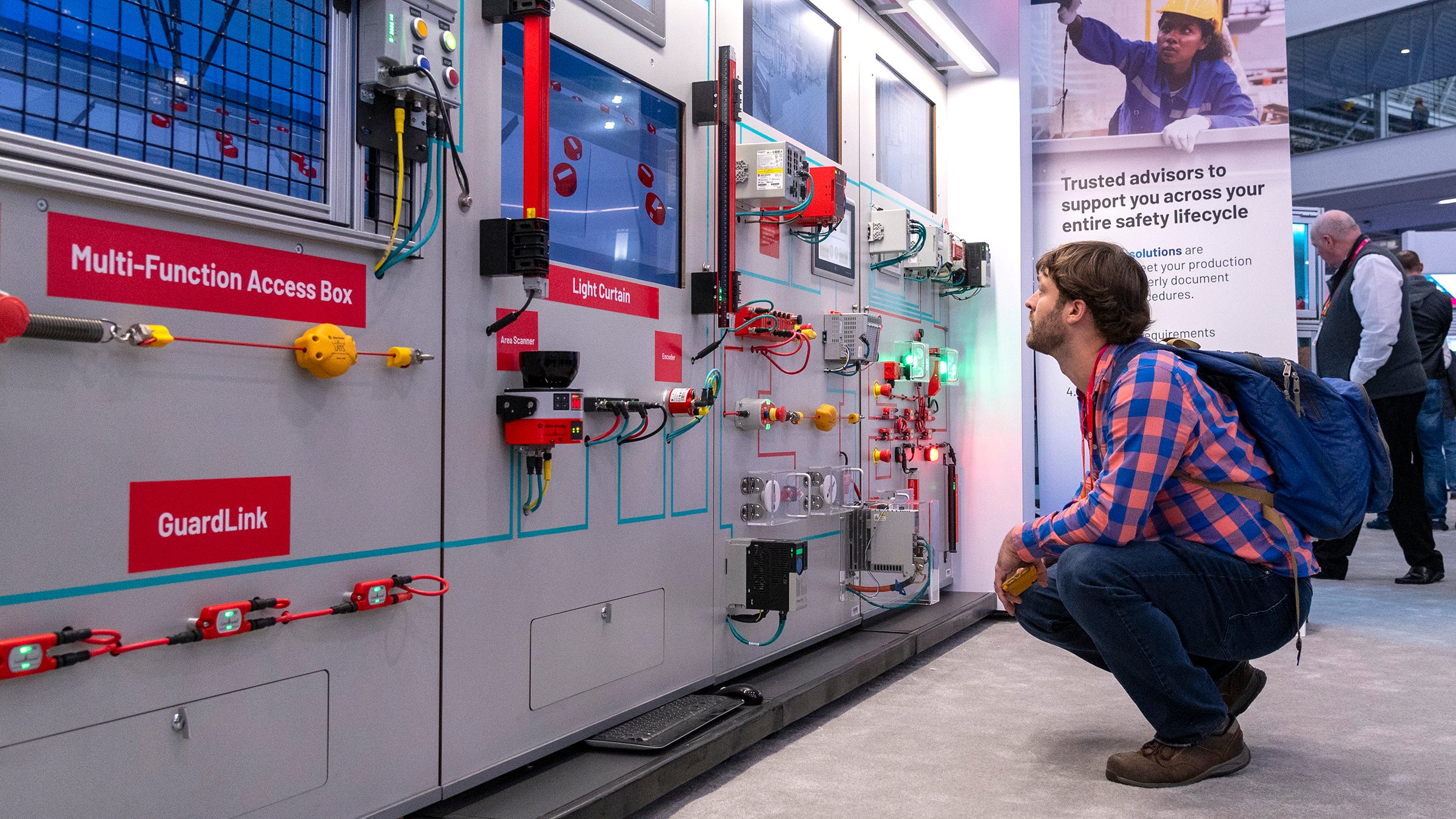 Man crouched down looking at Rockwell Automation products on display at Automation Fair 2023