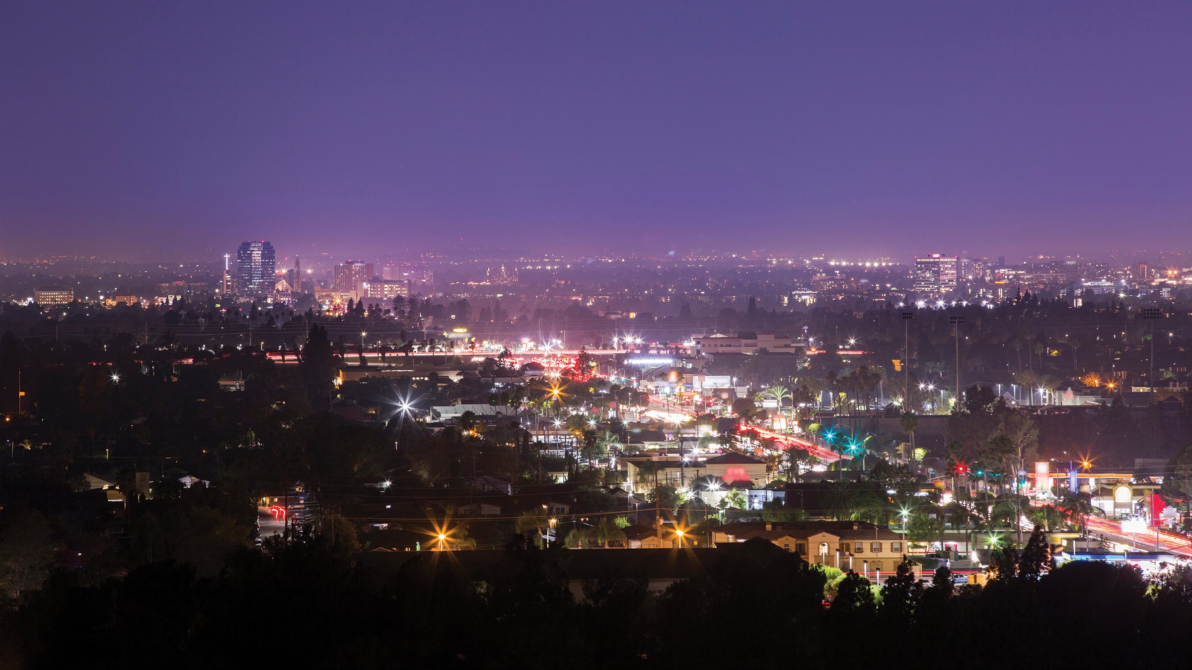 Nighttime view of the converging Orange and Anaheim skylines in Southern California.