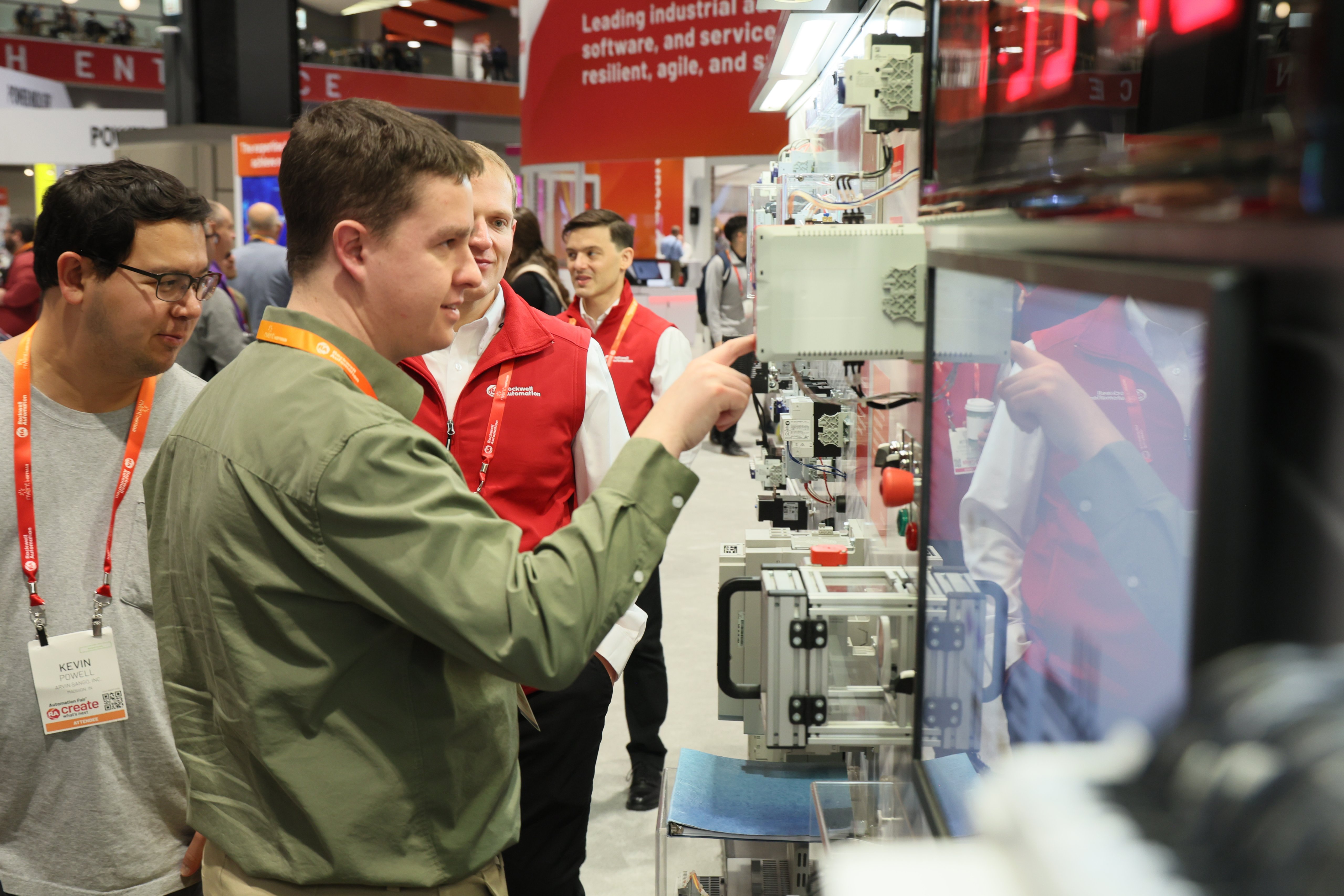 A man points to a piece of equipment at the Automation Fair trade show