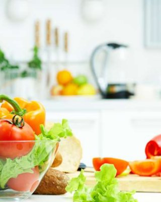 Ingredientes para fazer uma salada, incluindo tomates, alface e ovos no balcão de uma cozinha