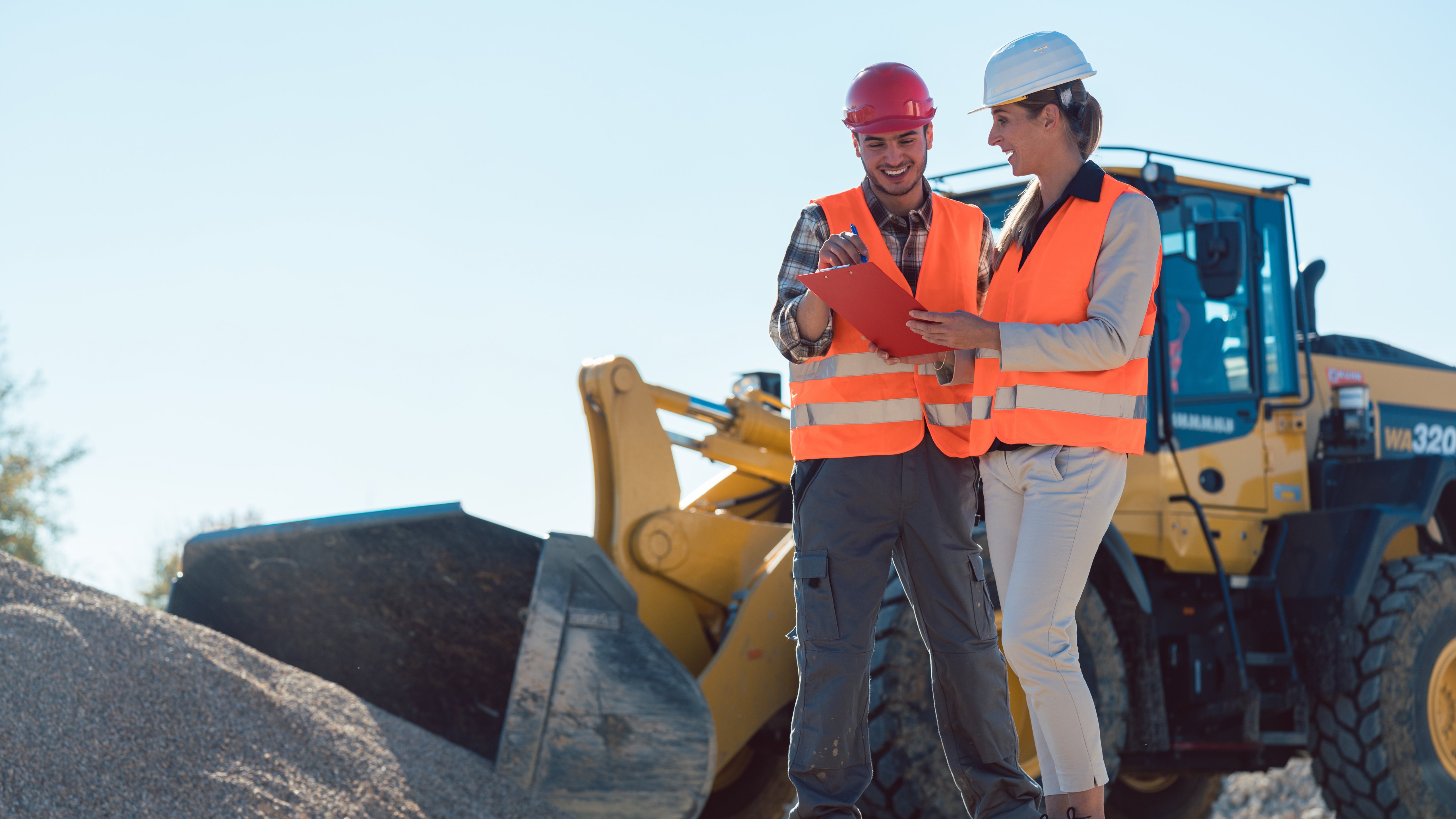 Man and woman worker on construction site talking