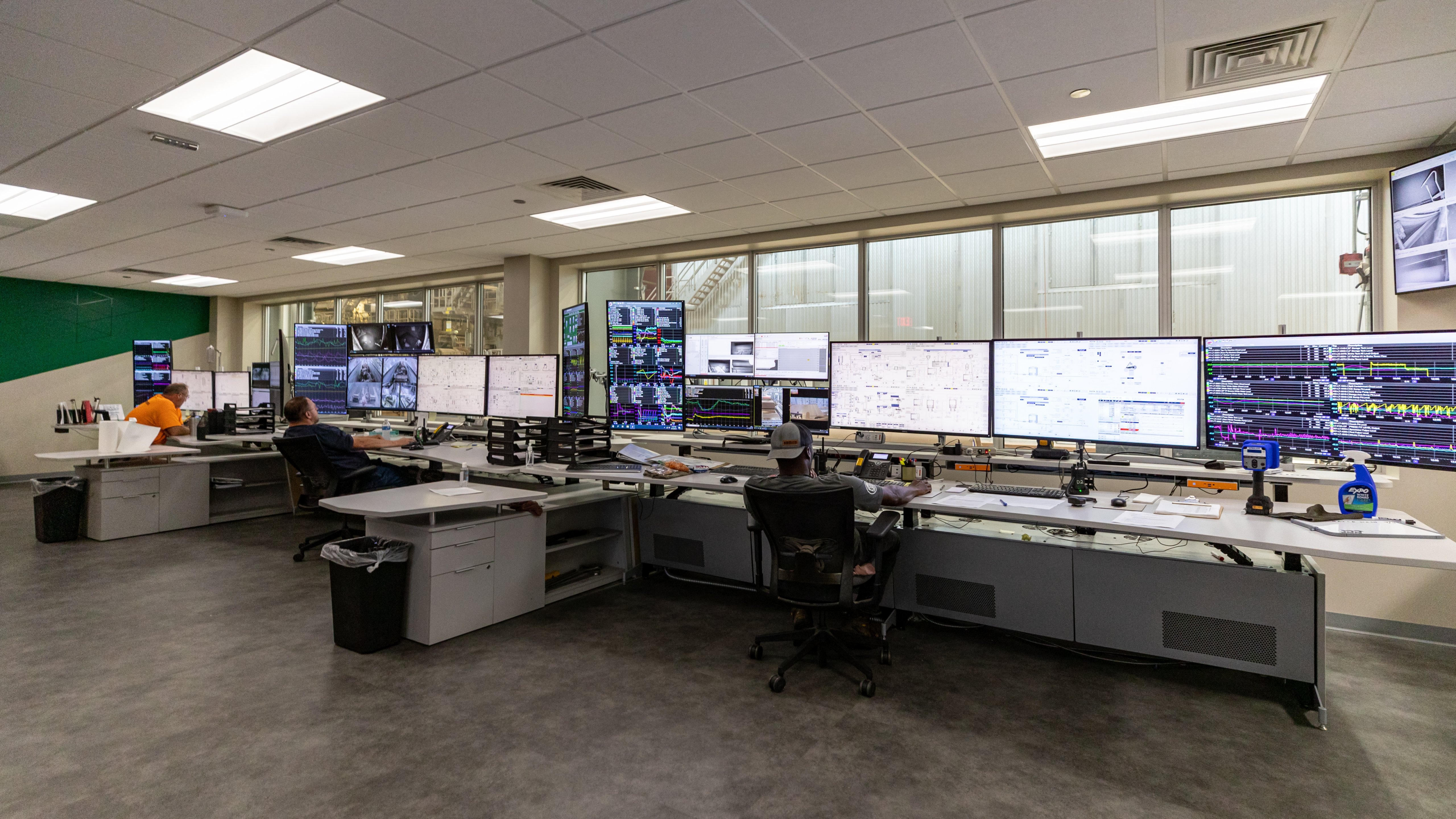 View of a man looking at multiple screens in a mill control room