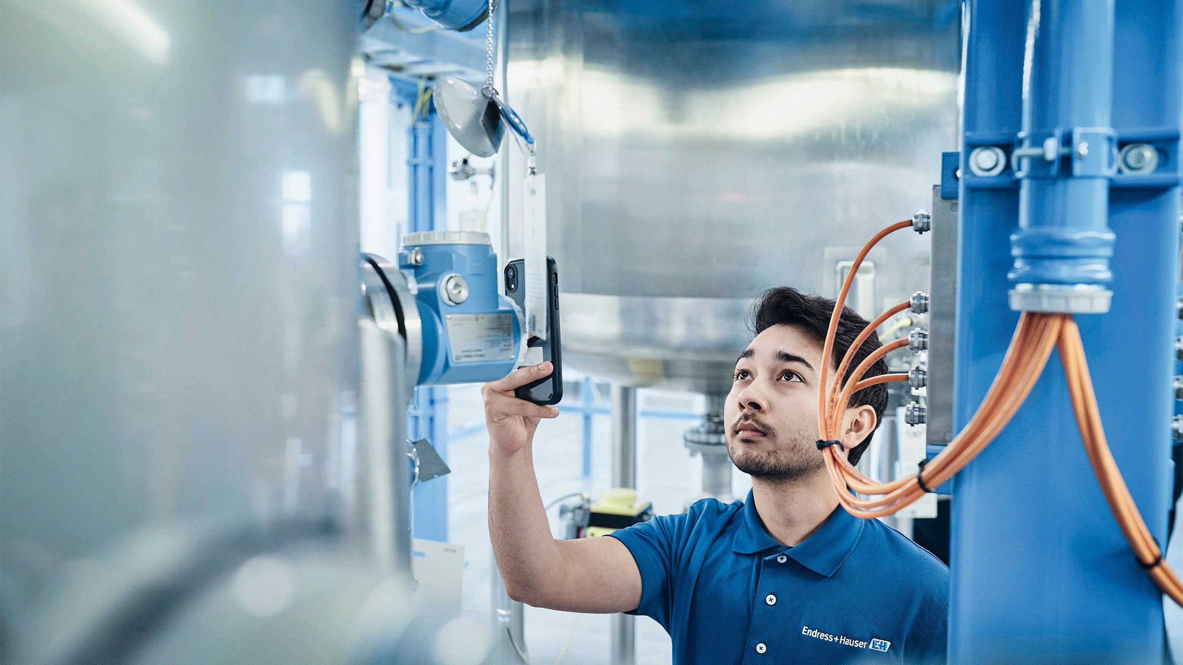 Engineer checking digitized process instrumentation in a manufacturing plant.