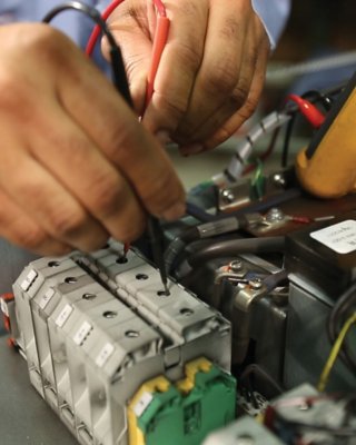 Close-up of a repair technician testing a PowerFlex drive