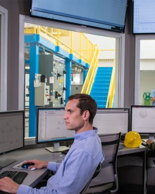 Mitarbeiter sieht FactoryTalk Network Manager Software auf seinem Monitor