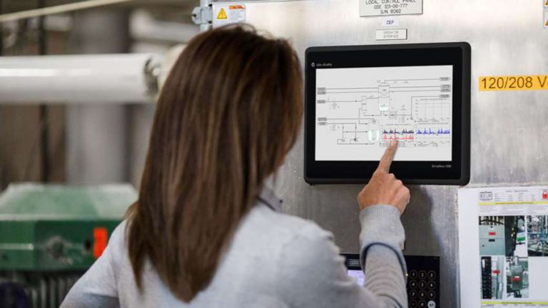 Una empleada frente a un monitor táctil obteniendo información del software FactoryTalk View Machine Edition