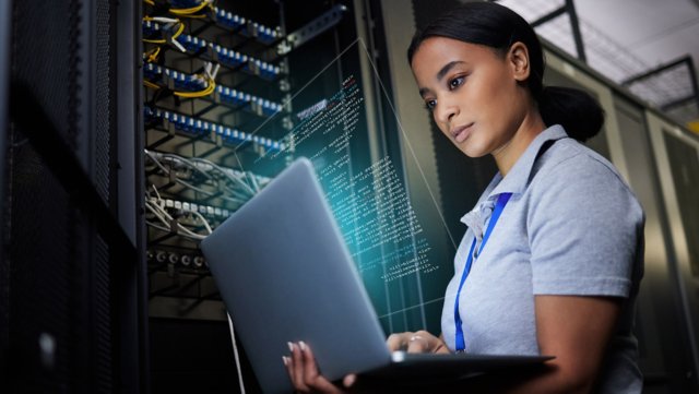 Ordinateur portable, réseau et centre de données avec une femme noire indénieur IT dans une salle de serveur sombre. Ordinateur, cybersécurité et analyse avec une programmeuse résolvant des problèmes ou procédant à des dépannages.