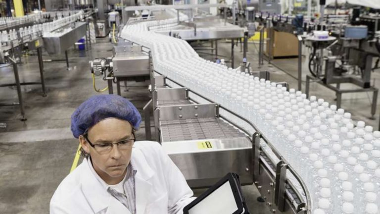 Mitarbeiter mit Haarnetz in einer Getränkeverarbeitungsanlage
