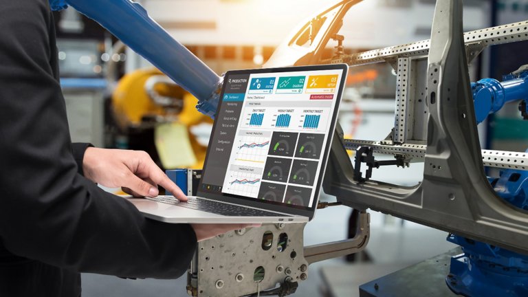 Usando tecnologia digital em um laptop em uma fábrica automotiva