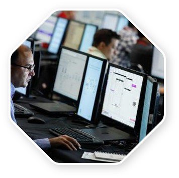  Man with glasses sitting and working in front of multiple computer screens