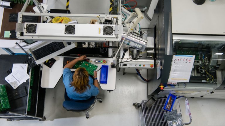 Una mujer sentada y trabajando en la automatización de fabricación y ensamblaje