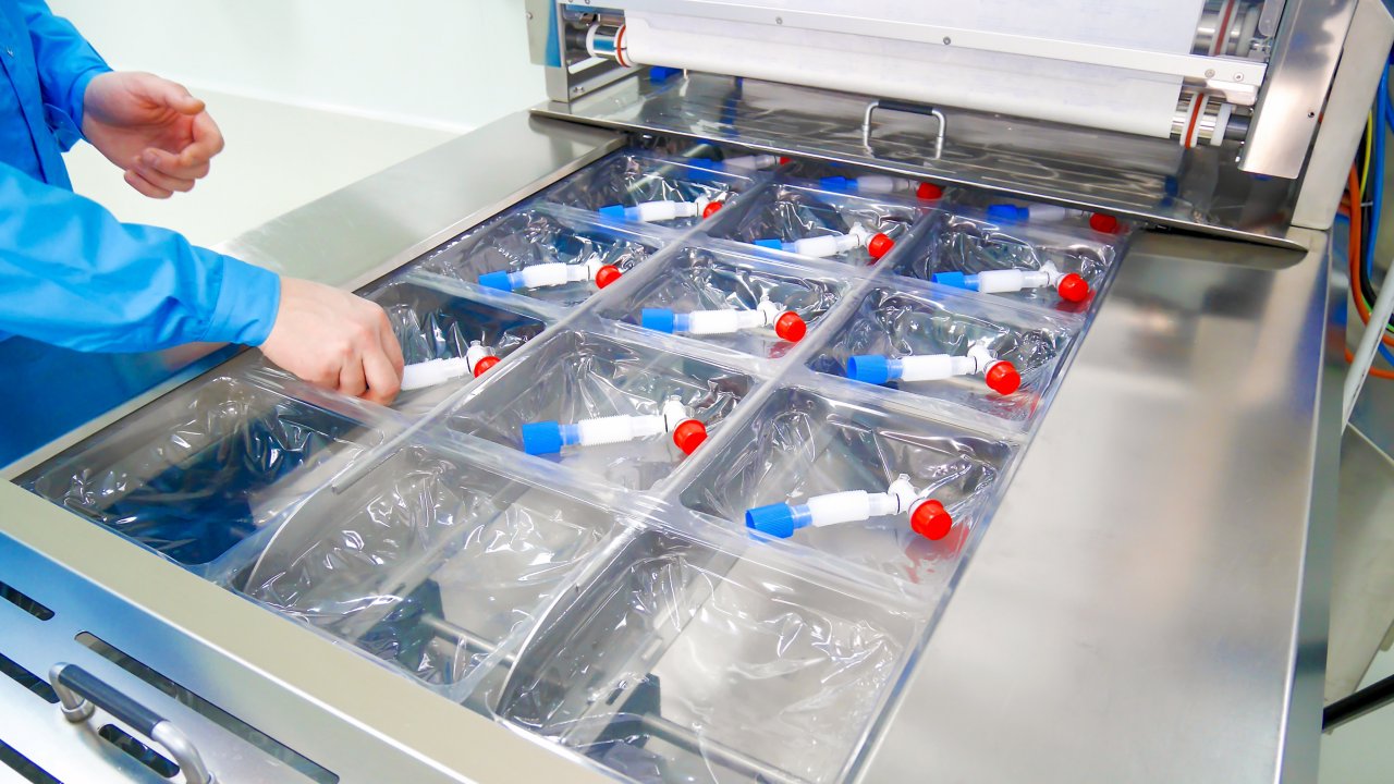 Ein Arbeiter im Bereich Life Sciences stellt eine Reihe medizinischer Geräte zum Versand in eine Schutzverpackung.