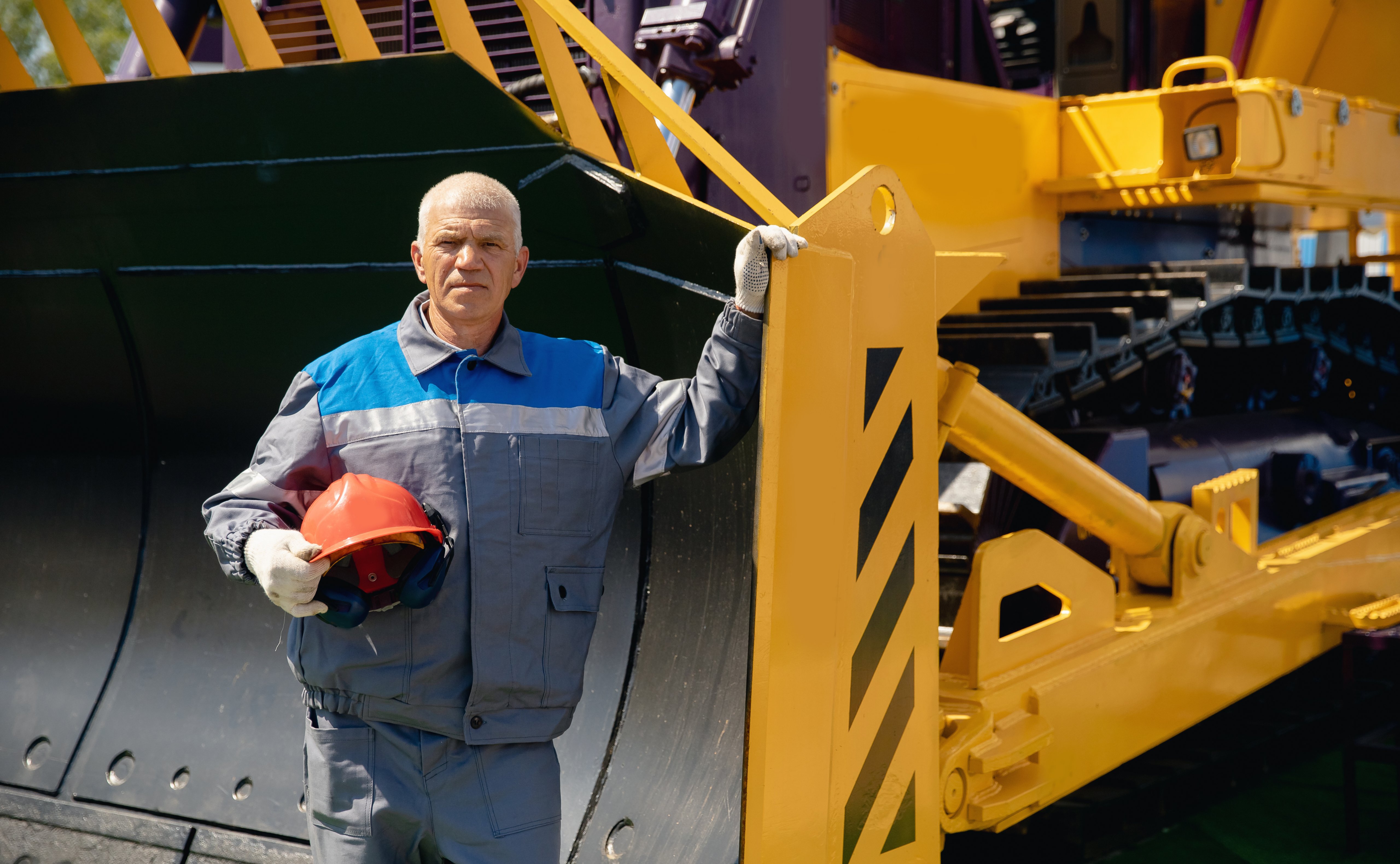 Portrait of industry mechanical worker on bulldozer on open pit mine.