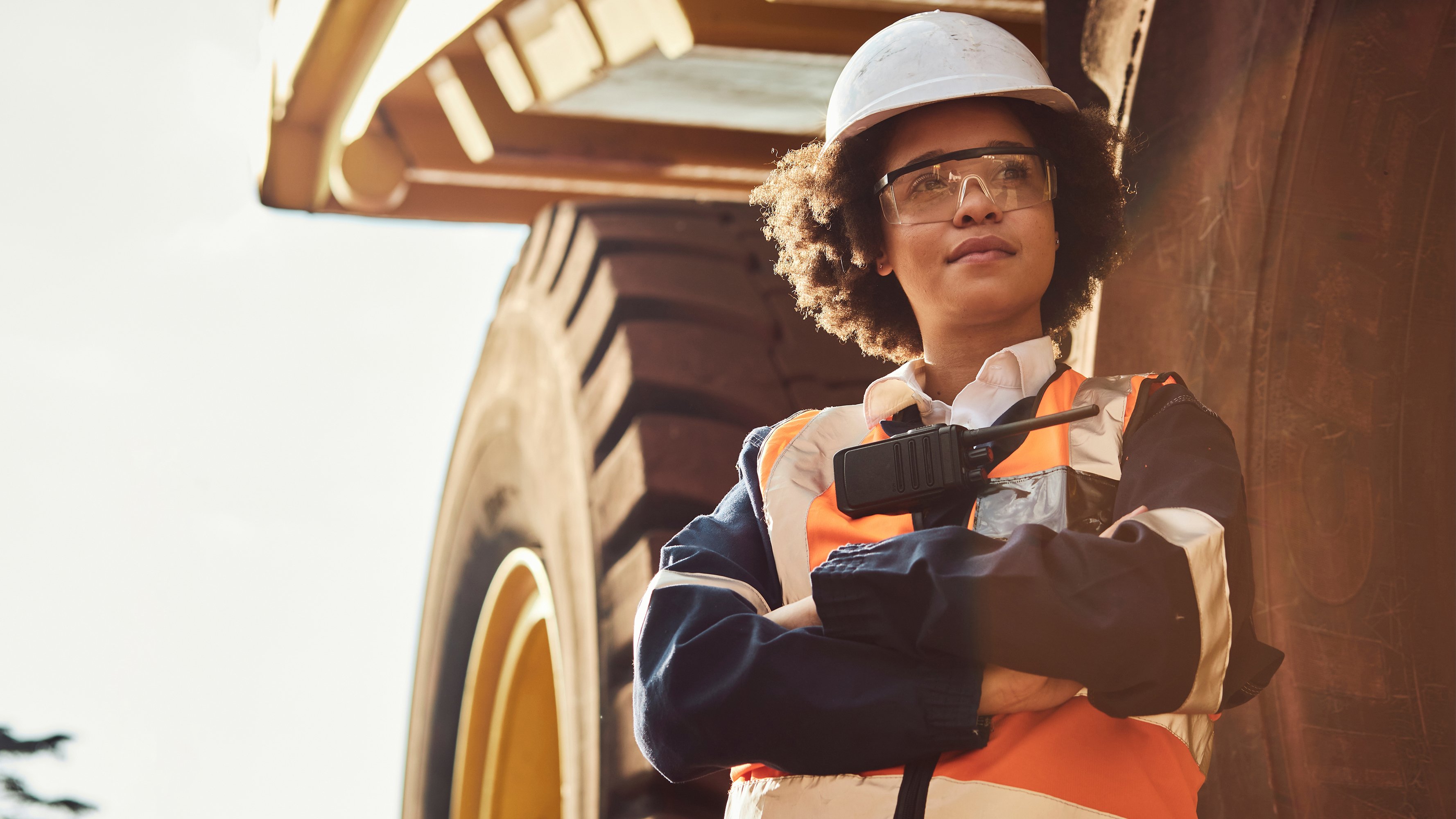 Mining young worker standing in front of large mining truck