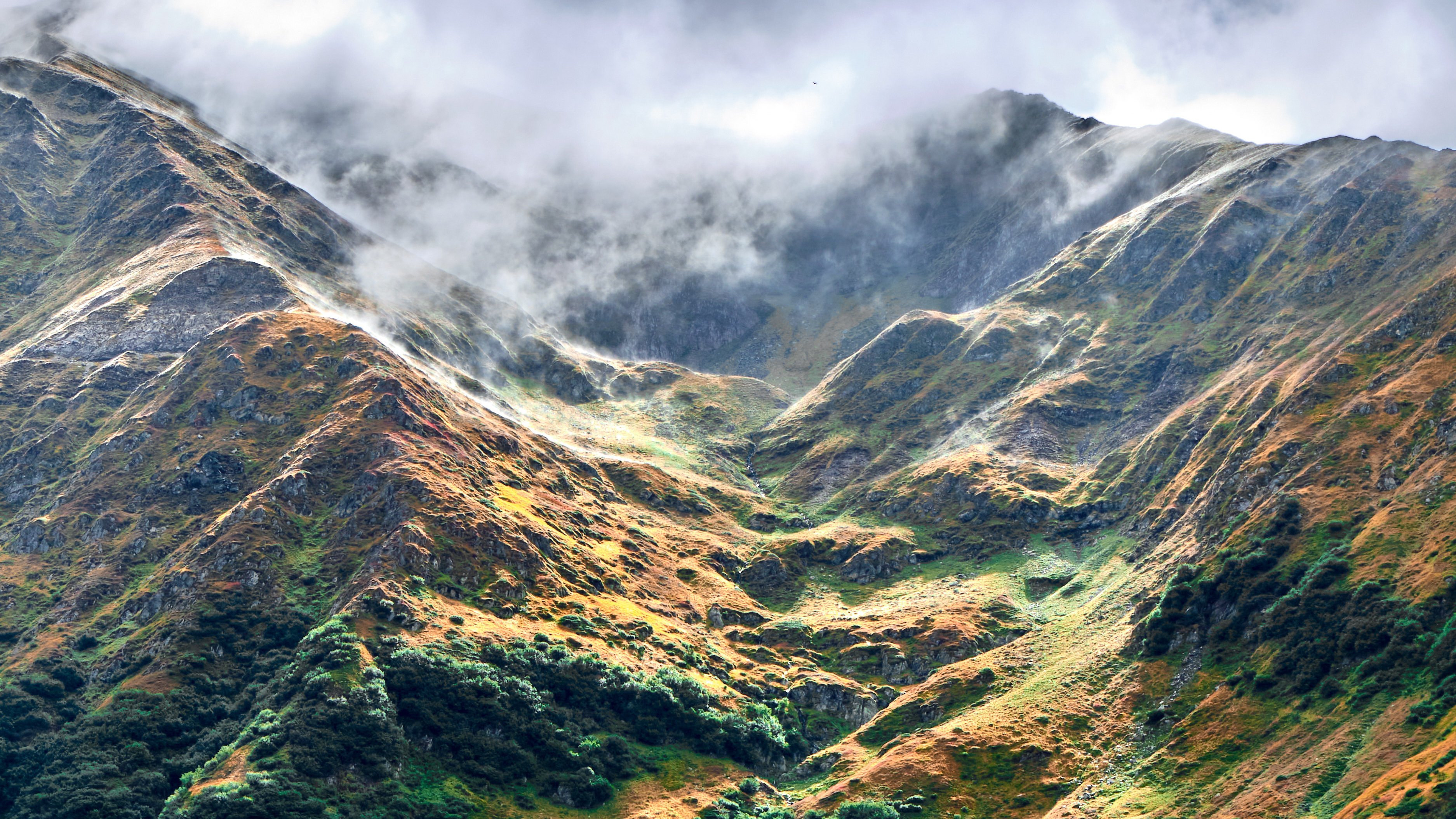 Vertical shot of the beautiful Fagaras mountains in Romania covered with clouds