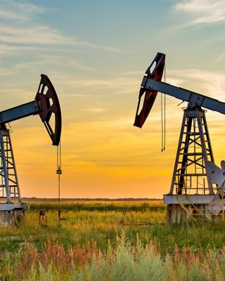 黃昏時分，正在工作的陸上石油與天然氣油田的景象與兩台抽油機的特寫。