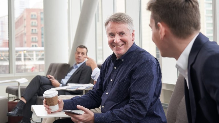 Three executives sitting smiling having a conversation