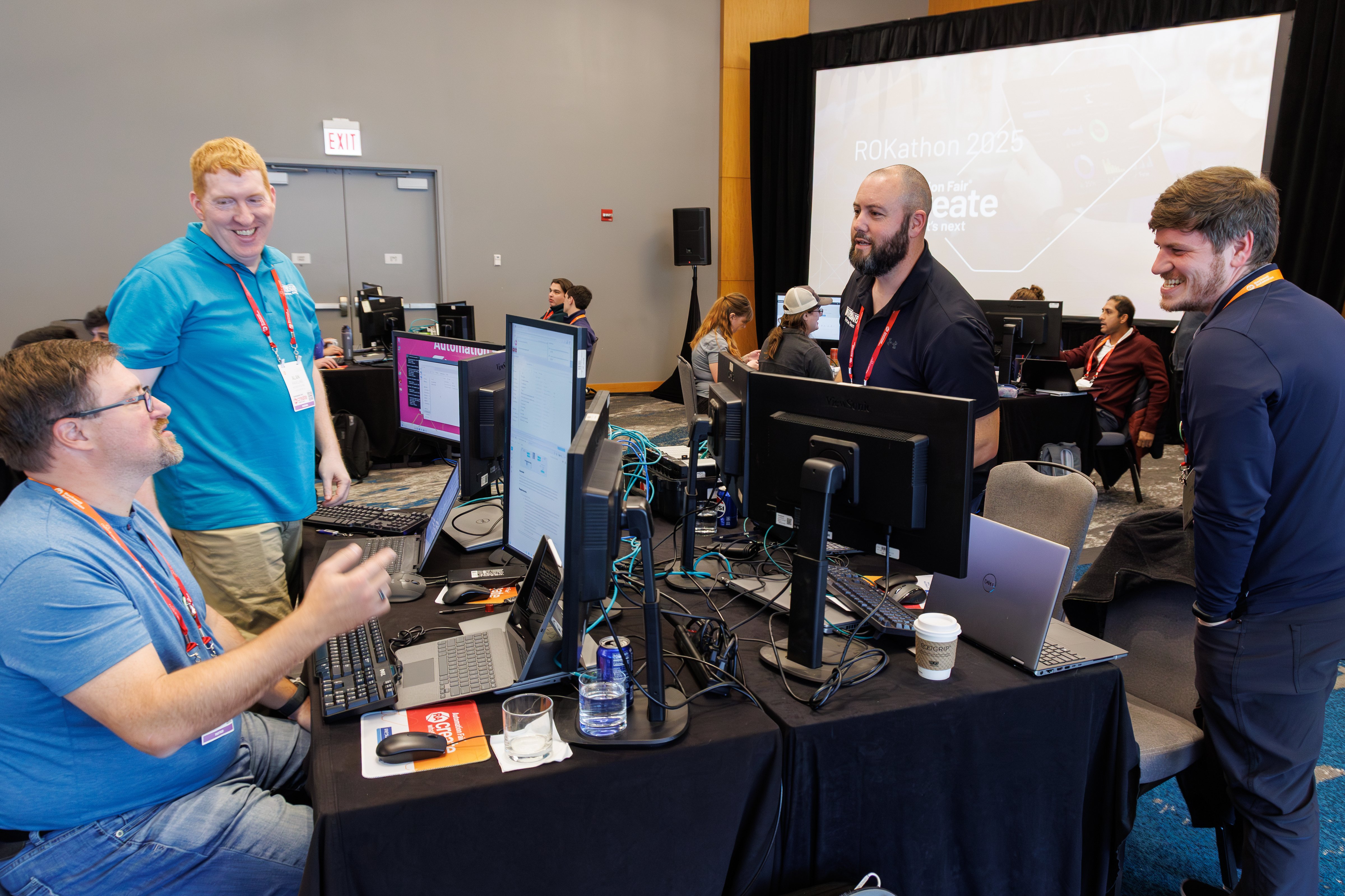 4 men have discussion around computers