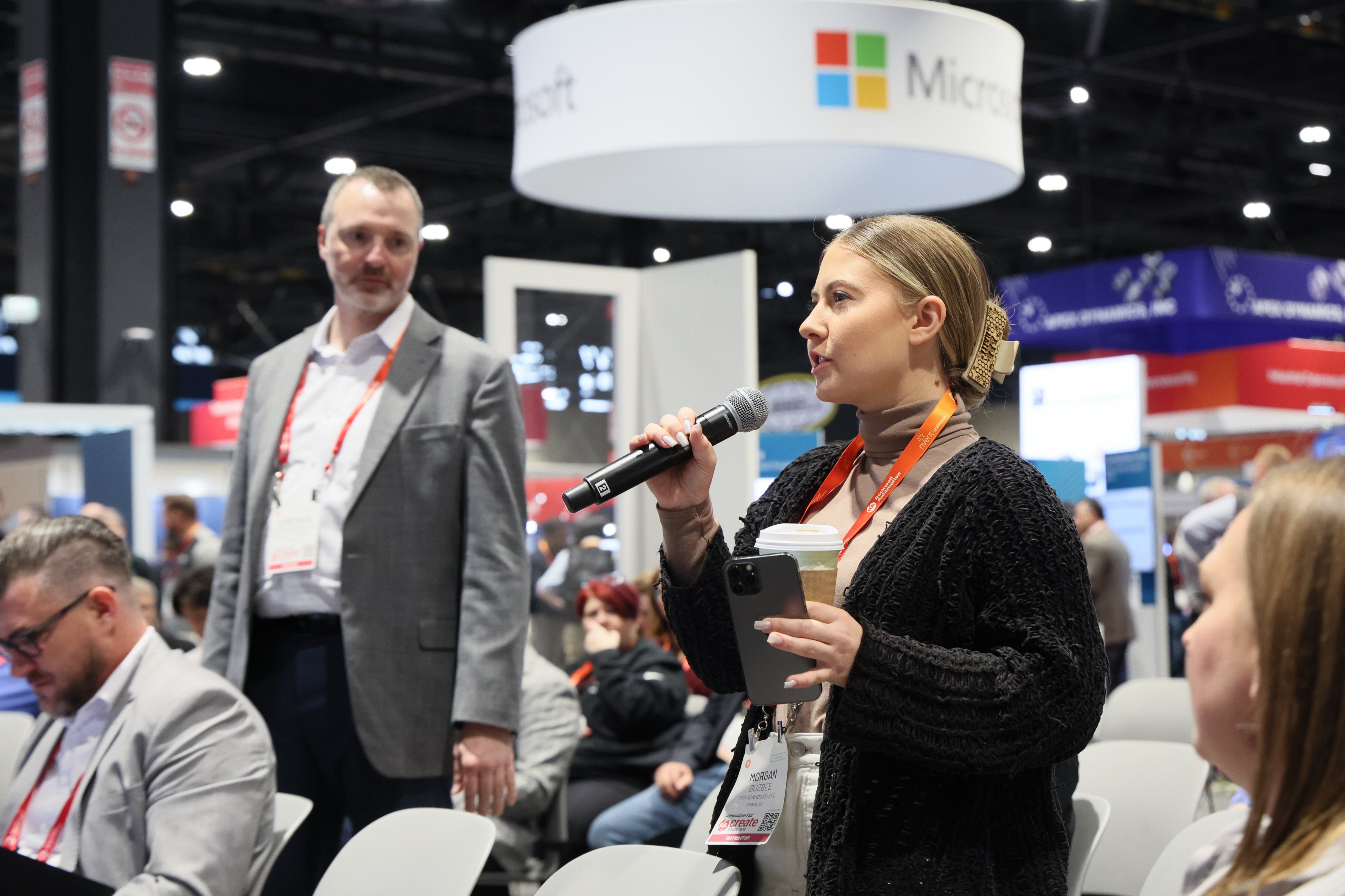 A woman holding a microphone and talking at the Discovery Theater at Automation Fair 
