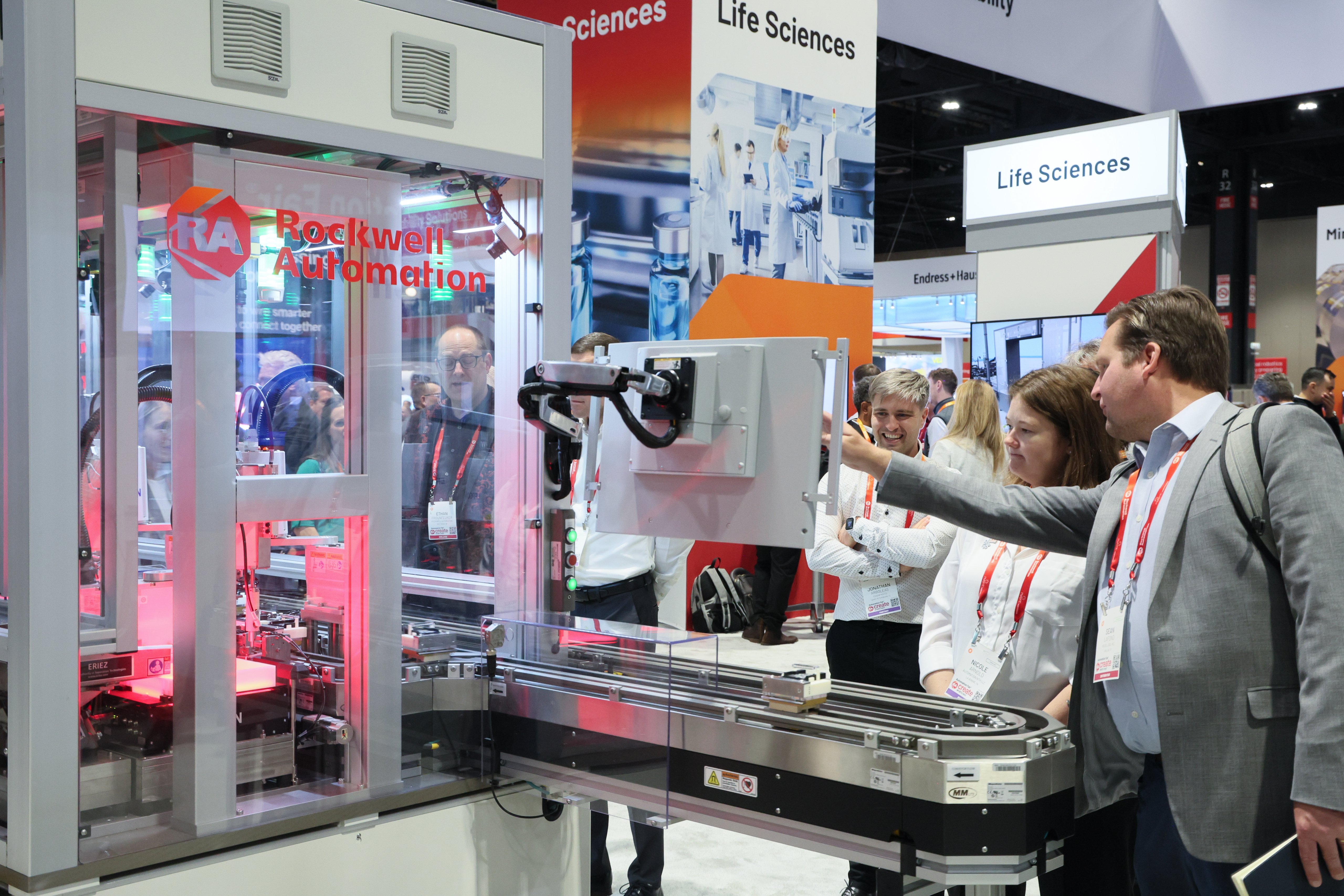 A man points to a screen on automation equipment
