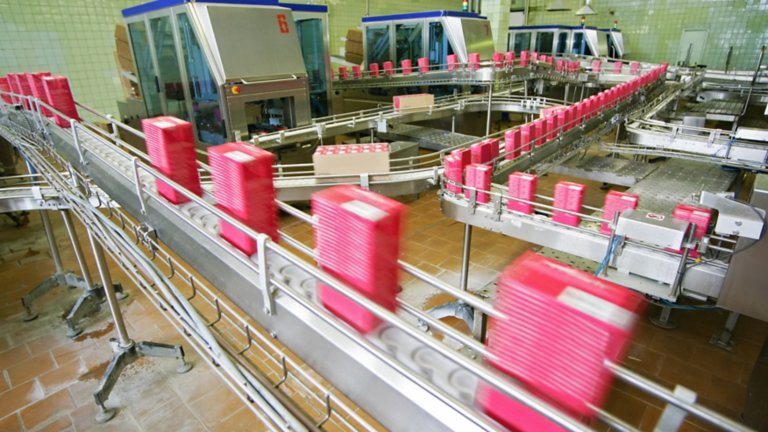 流水线利用智能电机控制设备在工厂车间移动粉红色容器