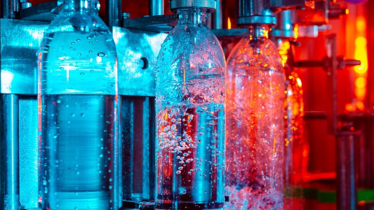 Water bottling line for processing and bottling pure spring water, with aqua and red lighting.
