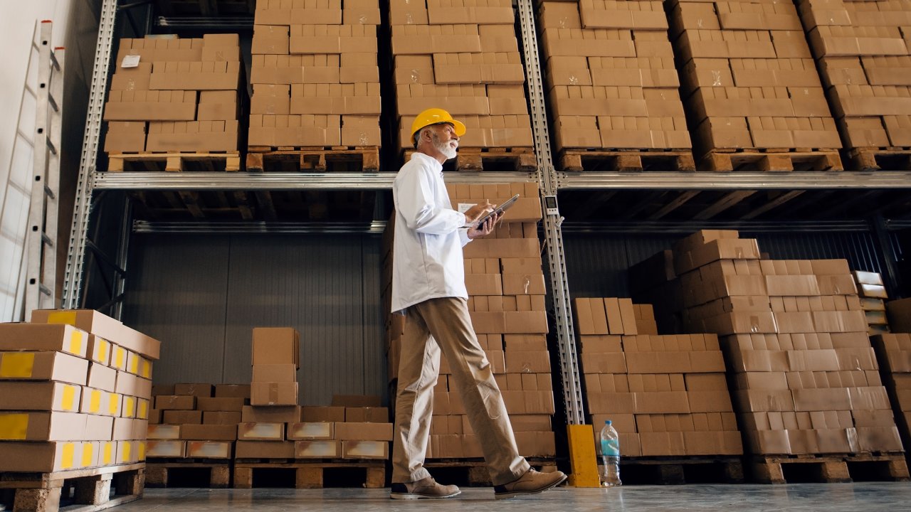 Man standing in front of large wall storage filled with boxes.