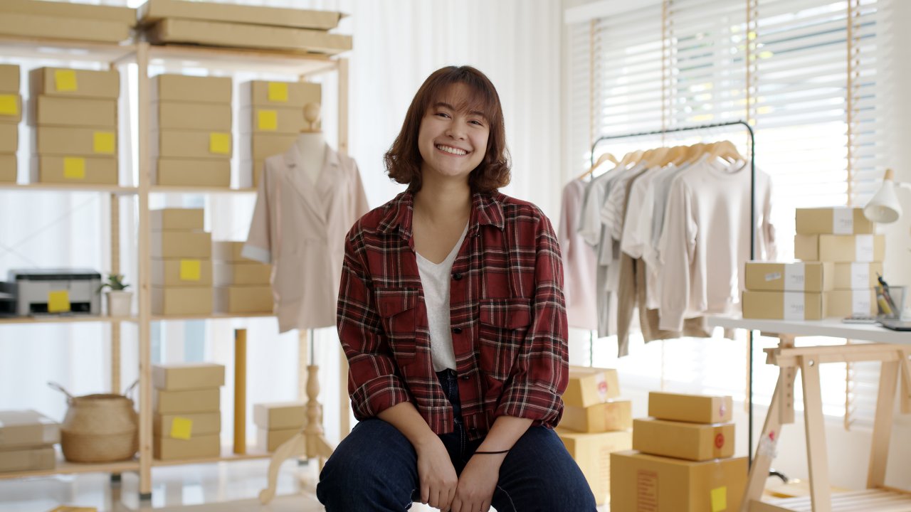Woman standing in front of clothing shipping boxes